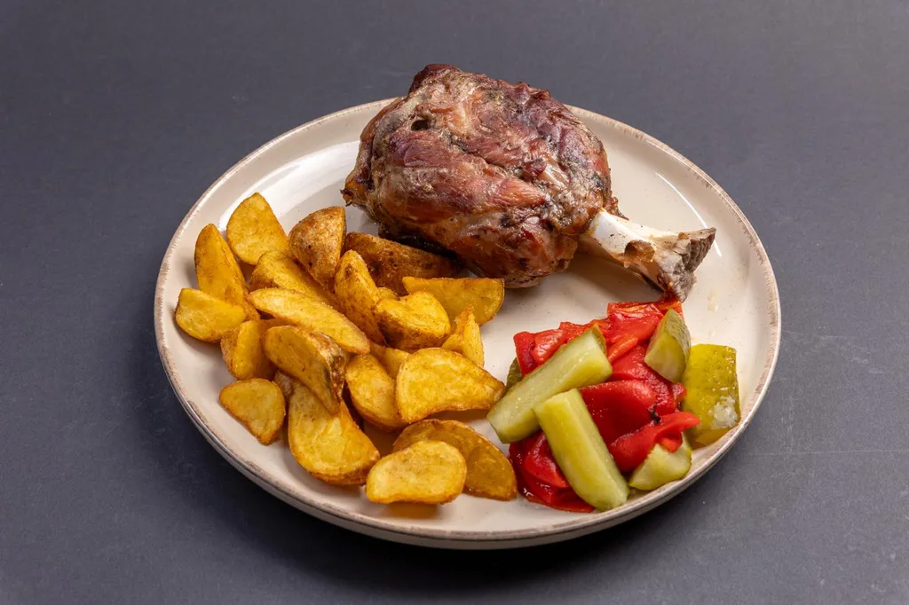 Ciolan de porc cu garnitură și salată de murături